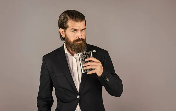 Always with me. Flat metal bottle for alcohol. man with elegant look. bearded hipster in suit hold metal flask for alcohol. Alcohol drink concept. Have alcohol drink with you. copy space