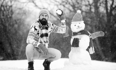 Hadi yapalım şu işi. Sakallı adam kardan adam yapar. Mutlu yıllar. Kış mevsimi. Mutlu noeller. Kış tatili Soğuk havada sıcak kazak. Adam eğleniyor. Mutlu hipster Xmas için hazır