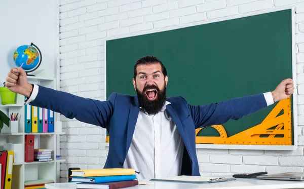 results in studying. informal education. male student sit in school classroom while lesson. pass the exam. learning the subject. shouting man with beard celebrate success