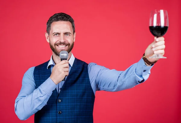 Glad orakad man i business casual stil tala i mikrofon lyfta glas rött vin, brödrost — Stockfoto