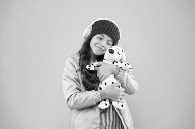 Seni çok seviyorum. Mutlu küçük kız köpek oyuncağı oynuyor. En sevdiği renk pembe. Küçük çocuk müzik kulaklığı dinler. çocuk uzun kıvırcık saçlı. Sıcak kış mevsimi. Hayvan bakımı. Soğuk hava için sıcak kıyafetler