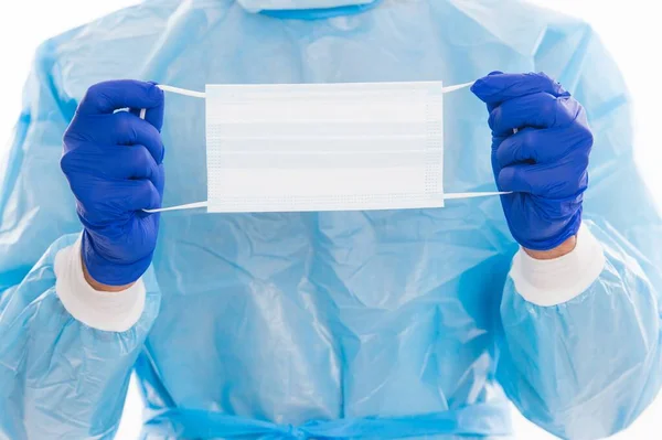 Респиратор медицинская маска для защиты в руках врача с хирургическими перчатками и костюм безопасности от коронавируса пандемии, ковидный вирус. — стоковое фото