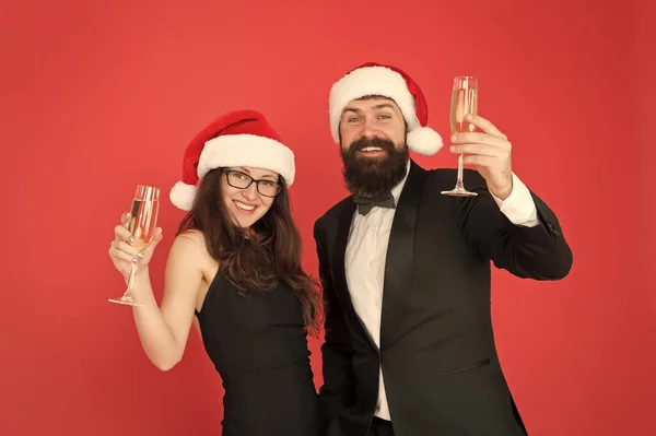 Irodai karácsonyi buli. Boldog karácsonyt és éljenzést mindenkinek. üzletember és lány pezsgőt isznak. Karácsonyi buli. A szerelmesek ünnepelik az új évet. szmoking férfi nő télapó kalap — Stock Fotó