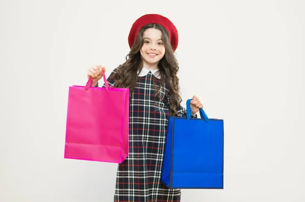 De compras. niño con bolsa de compras. pequeño adicto a las compras de belleza. Regalo de vacaciones. niño parisino en amarillo. chica feliz con el pelo rizado largo en boina. Niña en sombrero de estilo francés. tiempo de compra —  Fotos de Stock