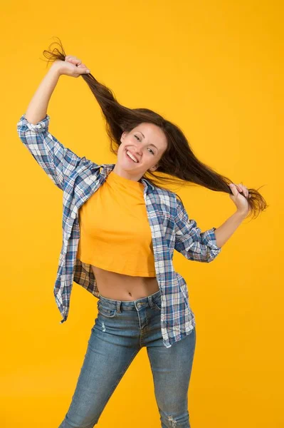 J'ai toujours voulu être coiffeur. Femme heureuse tenir les cheveux longs fond jaune. Salon de beauté. Salon de coiffure. Shampooing et conditionnement. Soins sans enchevêtrement — Photo