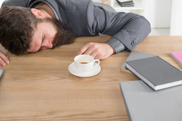 Un homme d'affaires fatigué dort au bureau. patron s'est endormi sur la table. Un homme dormant sur son lieu de travail. café va m'aider. homme ennuyé et épuisé dormir au travail. besoin de pause pour se détendre. être paresseux — Photo