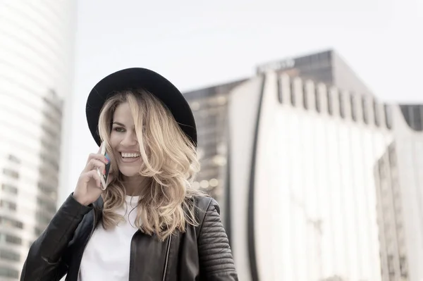 Chica en chaqueta de cuero de moda con teléfono celular. — Foto de Stock