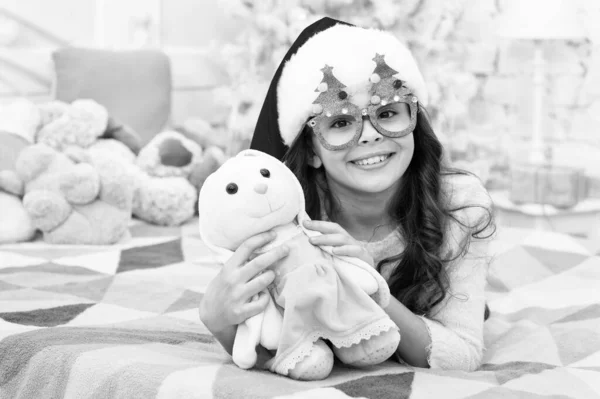 Atmosphère de vacances. Esprit de Noël. Vacances de Nouvel An. Petit enfant porter santa chapeau célébrer le nouvel an à la maison décoré fond intérieur. Enfant fille dans la chambre avec des jouets. Bonne année. Liste de souhaits — Photo