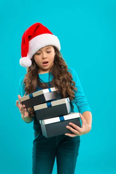 Felices fiestas de invierno. Pequeña chica sorprendida. Regalo para Navidad. Infancia. Niña con sombrero de santa. Compras de Navidad. Fiesta de año nuevo. Chico Santa Claus. Feliz Año Nuevo —  Fotos de Stock