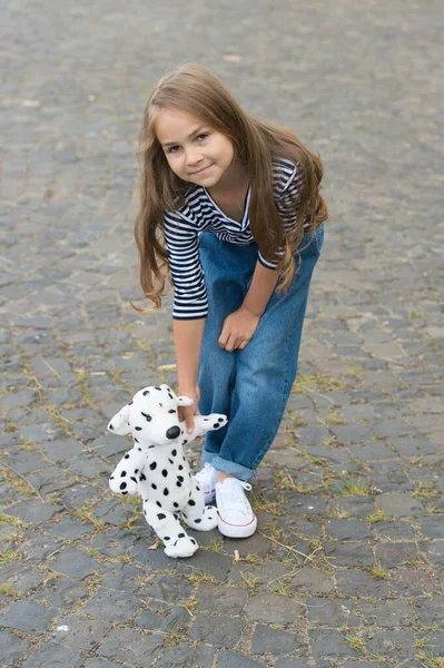 すべてのおもちゃには喜びの精神があります。屋外で柔らかい犬と幸せな子供の遊び。ゲームと遊び。幼少期の活動。幼稚園と遊び場。おもちゃ屋さん。幸せを売る — ストック写真