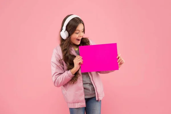 Verrast kind in headset luisteren lied en de presentatie van muziek app voor kinderen op leeg papier met plaats voor kopieerruimte, elearning — Stockfoto