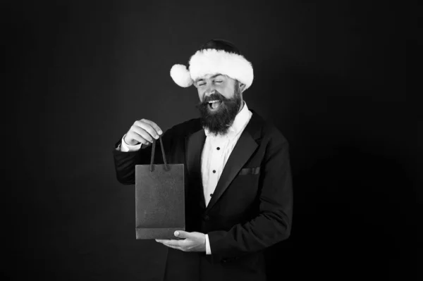 Een man met baard houdt boodschappentassen vast. Koop nieuwjaarsgeschenken. Winkelen voor cadeautjes. Mooie aankoop. Koop een breed scala aan stijlvolle en functionele kleding. Aanvullende diensten. Bespaar op aankopen. Winkelen met vreugde — Stockfoto