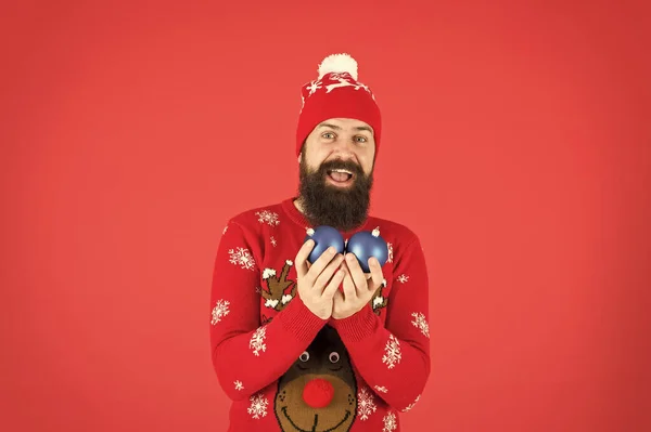 Evite a ansiedade esmagadora quando confrontado com estressores de férias. Decorações de inverno. Ano Novo. Hipster homem barbudo alegre usar camisola de inverno e chapéu segurar bolas. Festa de Natal. Férias de inverno — Fotografia de Stock