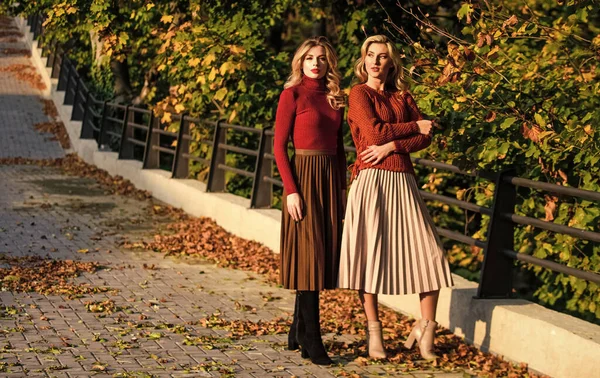 Fashionable clothes. Femininity and tenderness. Friends girls. Fall fashion. Pleated skirt fashion trend. Women walking in autumn park. Autumn stylish outfit. Adorable ladies enjoy sunny autumn day — Stock Photo, Image