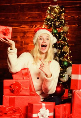 Şölen dekoru. Neşeli kız, kırmızı Noel Baba şapkası. Yeni yılı evde kutlarız. Xmas bayram hediyesi. Boks günü. Mutlu kadın hediyeleri sever. Kış alışverişi. Son hazırlıklar. Noel zamanı
