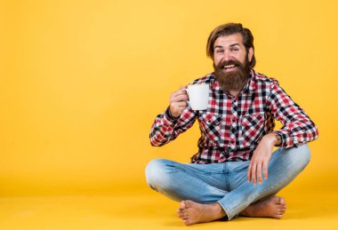 Mutlu sakallı adam sabah kahvesini içiyor. Adam fincandan sıcak çay içiyor. Sana da günaydın. Enerjik, sıcak bir içecek. İlham için biraz kahveye ihtiyacım var. Güne mükemmel bir başlangıç. Boşluğu kopyala