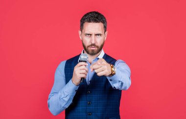 Profesyonel satıcı mikrofona konuşarak işaret eden kırmızı arka plan, sunum