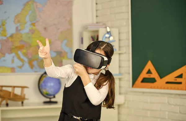 Headshot kills. Virtual classes. VR technology. schoolgirl using virtual reality helmet. Virtual reality headset. Teenager student girl in classroom. Play game. Explore cyber space. Digital world