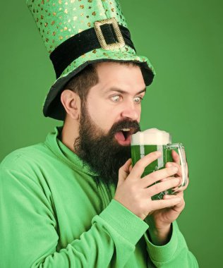 İrlanda barı. Bira içme kısmı kutlama. Festival ve tatil menüsü. Geleneksel boyalı yeşil bira. Alkol içeceği. Patrick 'in partisi başlasın. İrlanda geleneği. Vahşi sakallı hippi adam bira içiyor.