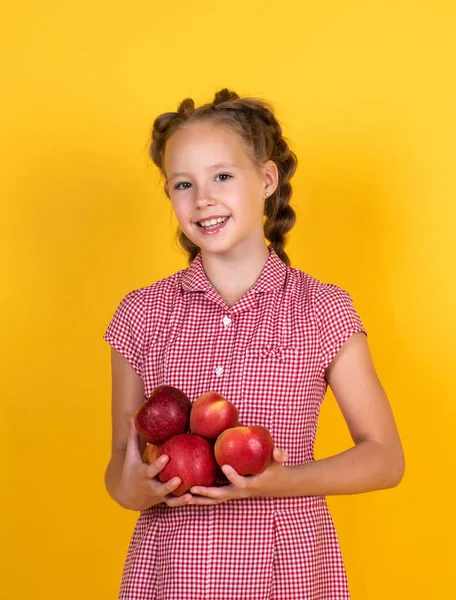 Ανοιξιάτικο. Ευτυχισμένο κορίτσι που κρατάει μήλα από τον κήπο. Το παιδί κρατάει φρέσκα φρούτα. παιδί τρώει κόκκινο μήλο. καλοκαιρινό υγιεινό φαγητό. χορτοφαγική δίαιτα. φρούτα την φθινοπωρινή συγκομιδή. Υγιεινή διατροφή το φθινόπωρο — Φωτογραφία Αρχείου