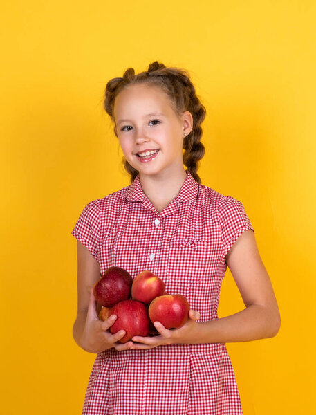 Spring style. happy girl holding apples from garden. kid hold fresh fruit. child eating red apple. summer healthy food. vegetarian dieting. fruits at fall harvest. Healthy nutrition in autumn