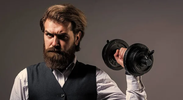 he is strong. brutal mature hipster in suit with dumbbell. business and sport. express real power. be strong in business and life. successful male with beard and moustache. businessman hold barbell