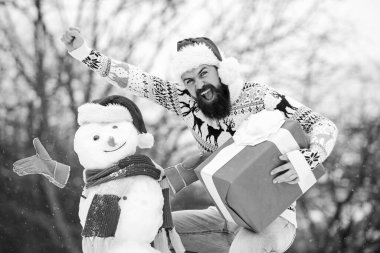 Neşeli hissediyorum. Sakallı adam kardan adam yapar. Kış mevsimi aktivitesi. Mutlu noeller. Noel Baba hediyesini dışarıda verir. Mutlu hipster Noel 'e hazır. Kış tatili Soğuk havada sıcak kazak