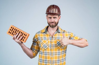 İnşaatçı başarının tadını çıkarır. Tuğlalı adam mimar. Adam işçi üniforması giyiyor. Kasklı yakışıklı bir müteahhit. Olgun adam kareli gömlek giyer. Profesyonel inşaatçı ya da tamirci. İnşaat mühendisi