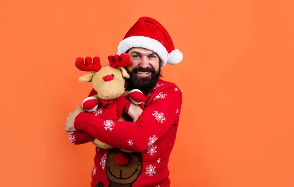 Šťastný vousatý muž v Santa Claus klobouk a pletený svetr s hračkou oslavit Nový rok zimní dovolená, vánoční dárek — Stock fotografie