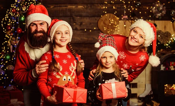 A szülők és a gyerekek karácsonyi ajándékokat bontogatnak. Karácsonyi hagyomány. Boksz nap. Kellemes ünnepeket. Apa szakállas férfi és anya aranyos lánya karácsonyfa háttér. Töltsön egy kis időt a családjával. — Stock Fotó