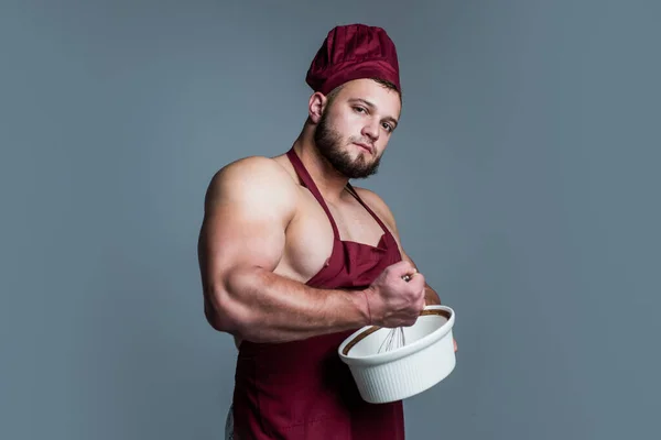 Guy eating healthy. food for athletes. sexy man with body muscles in cook apron. professional handsome chef cooking in kitchen. culinary and cuisine. muscular man use utensils — Stock Photo, Image