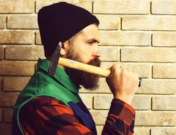 Бородатый строитель держит молоток серьезное лицо — стоковое фото