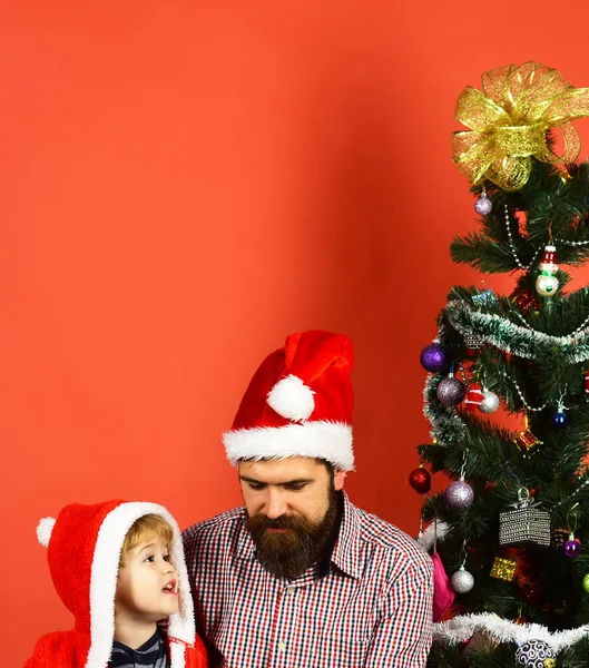 髭を生やしたパパと子供がクリスマスツリーの近くで話す. — ストック写真