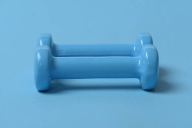 Mavi arkaplanda mavi plastik dambıllar