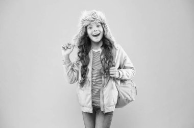 Kış tatili. Çocuk sıcak bez pembe arka plan. Mutlu çocuk kulaklı şapka. Çantalı kız eve git. Okul yılının sonunda. Artık sınav yok. Küçük mutlu kız okula geri döndü. İnan ve başarılı ol.