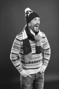 Soğuk hava akımları. Kış erkek moda koleksiyonu. Olgun bir adam sıcaklığın ve konforun tadını çıkarır. Noel tatili zamanı. Yeni yıl havasına girdim. Mutlu sakallı adam kırmızı arka plan. Örülmüş aksesuarlar.