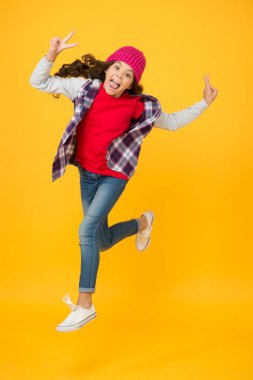 Enerjik çocuk modası. Uzun kıvırcık saçlı bir çocuk. Sonbahar modası. çocukluk mutluluğu. Kadın güzelliği kavramı. Samimi duygular. Özgürlük. Mutlu genç kız sıradan bir şekilde koşuyor. Okula geri dön.