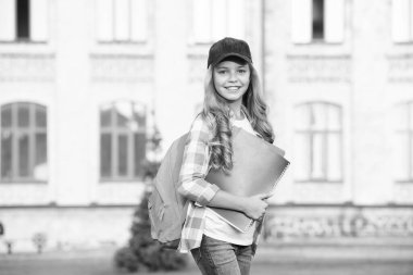 Çocuklar için edebiyat. Çocukluk gelişiyor. Defterle çalış. Okula dönüyorum. Okul çantalı çocuk. Sırt çantası taşıyan gülümseyen bir çocuk. Ödevlerimizi yapalım. Küçük kız kitabı tutuyor.