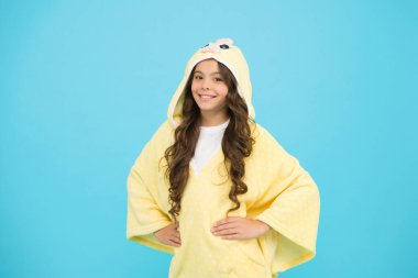 Hafta sonu tatili. Uzun saçlı çocuk pelüş pijama giyiyor. Çok güzel pijamalar. Kapüşonlu pijama giyen küçük bir kız. Rahat ve rahat hissediyorum. Çocuk modası. Ev kıyafetleri. Mutlu çocukluk