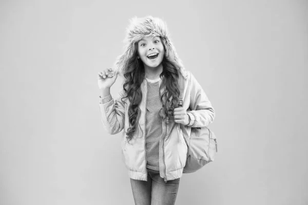 Vacaciones de invierno. niño tela caliente fondo rosa. sombrero de oreja niño feliz. colegiala con bolsa ir a casa. fin del año escolar. No más exámenes. Pequeña chica feliz de vuelta a la escuela. Creer y tener éxito —  Fotos de Stock