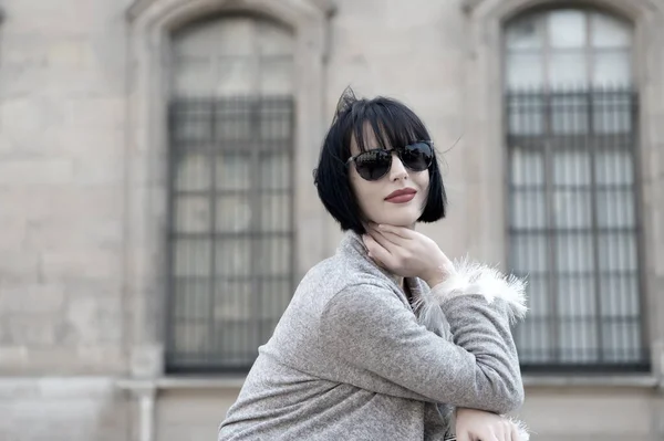 Mujer sensual en gafas de sol posan en París, Francia, la moda. Mujer de cabello moreno, labios rojos, maquillaje, belleza. Moda, accesorio, moda. Belleza, mira, maquilla. Cuidado de la piel, peinado, estilo — Foto de Stock