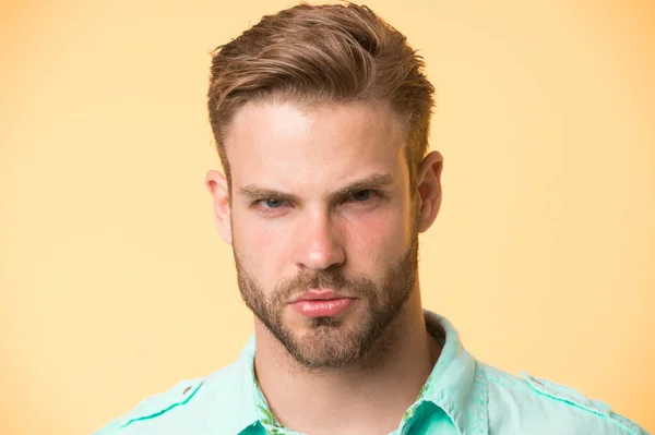 Homme barbu avec barbe sur le visage non rasé sur fond jaune. Macho avec un regard sérieux. Barbu et beau. Salon de coiffure et de coiffure. Soins et toilettage de la peau — Photo