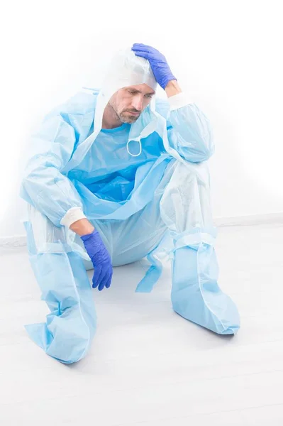 Vyčerpaný muž lékař epidemiolog má bolesti hlavy v ochranném kostýmu na koronavirus pandemické karantény izolované na bílém, laboratorní lékař — Stock fotografie