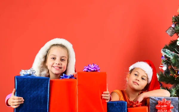 Hermanas en Santa Claus sombreros con cajas de regalo y paquetes Imagen De Stock