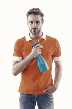 Evini tozsuz tut. Yakışıklı adam hijyen spreyi şişesini tutuyor. Ev hijyeninde dezenfektanlar ve antibakteriyeller. Ev temizliği. Temizlik ve hijyen. Mikropları durdur. Hijyen kullan.