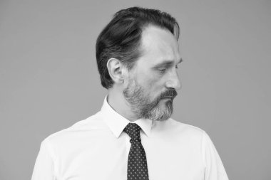 Yaş ve tecrübe. Yakışıklı, kendine güvenen bir manken şık beyaz bir gömlek giyer. Özgüven duygusu. Erkek modası. Moda dükkanı. Sakallı, olgun bir yüz. Gri sakalı var.