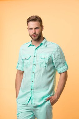 Adam rahat bir şekilde poz veriyor. Sakallı ve saç stili olan yakışıklı adam.