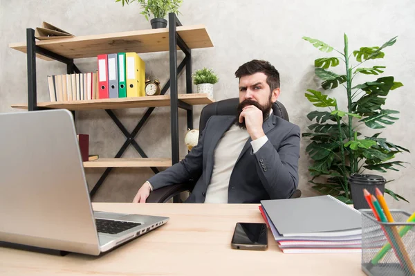 사업 전략을 개발하라. 위험 한 사업이죠. 집중하고 집중 해. 남자 수염 상사는 노트북을 들고 사무실에 앉아 있습니다. 사업 문제를 해결하는 관리자. 사업적 해결책을 책임맡고 있는 사업가 — 스톡 사진