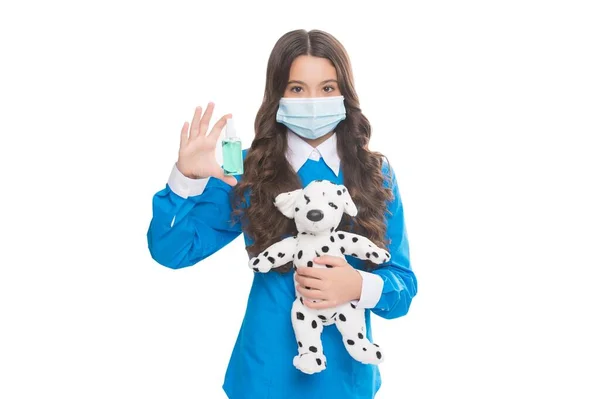穿着防护面罩的少女拿着清洁剂凝胶和狗玩具，隔离在白色、病毒大流行中 — 图库照片