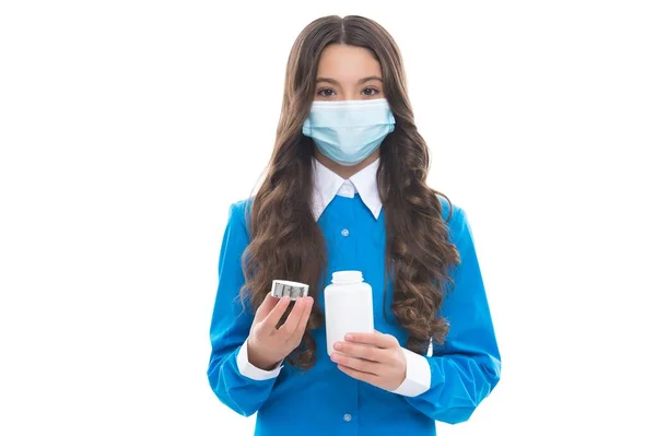 Flicka hålla vitaminer eller medicin läkemedel piller från feber bär skyddande medicinsk mask isolerad på vit, corona virus — Stockfoto